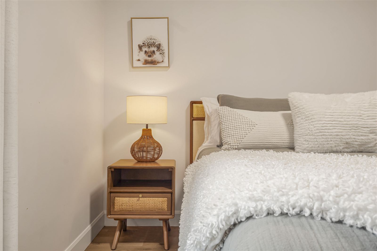 Chambre avec literie texturée et table de chevet en rotin