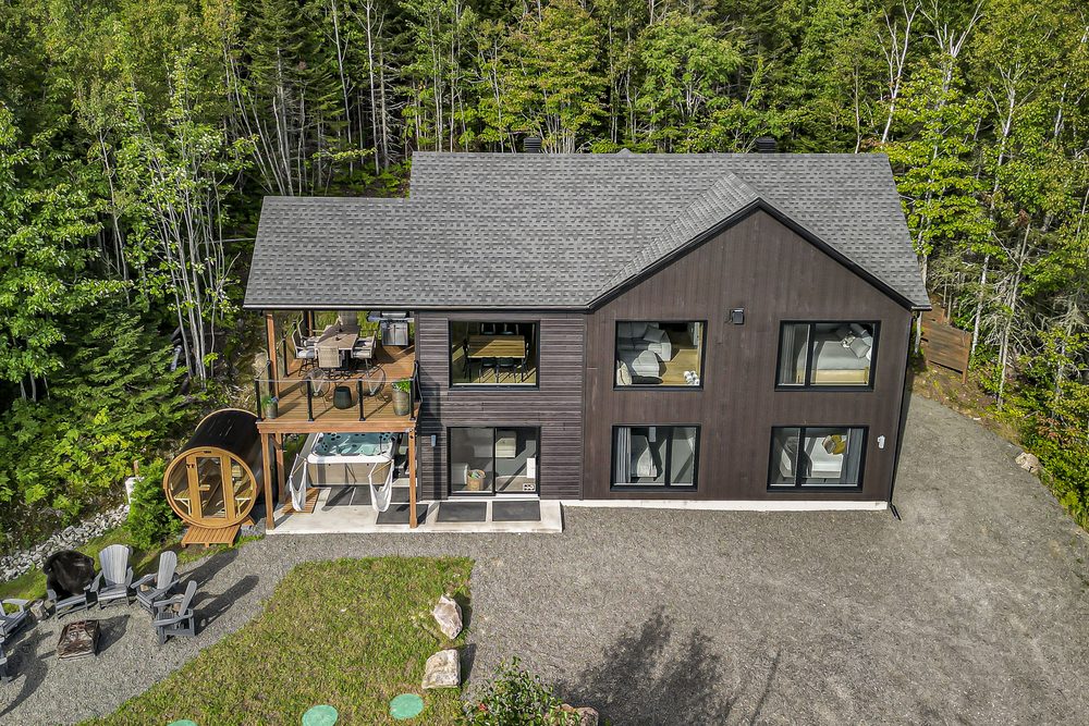 Aerial view of a contemporary chalet in the forest with spa, sauna and deck